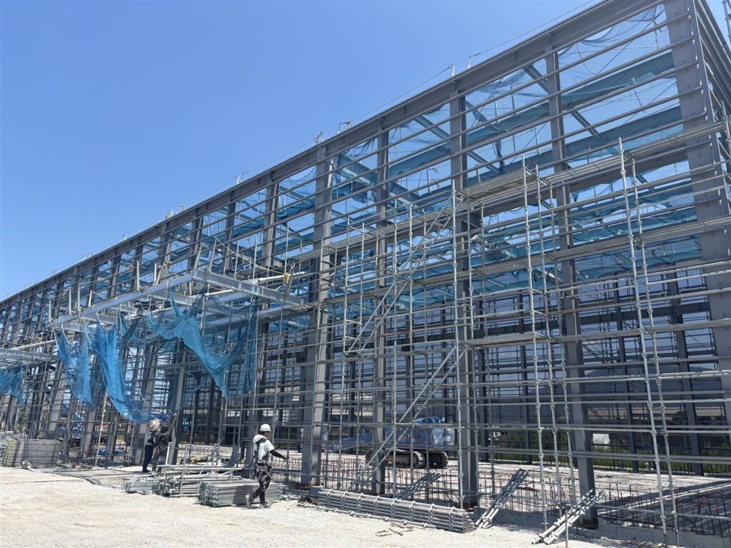 足場の組まれた鉄骨造工場の外観